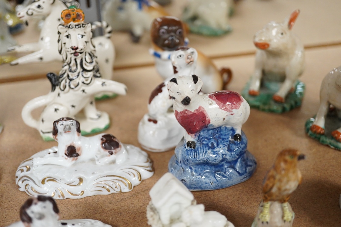 A collection of 19th/20th century Staffordshire and continental porcelain models of animals and birds, including a 20th century Meissen figure of a canary, two Continental porcelain Panthers, two similar recumbent dogs,